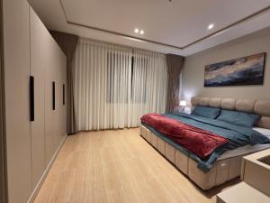 a bedroom with a large bed with a red blanket at Khobar Luxury Apartments in Al Khobar +54 photos