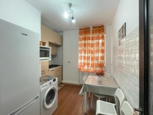 a kitchen with a table and a washing machine at Apartament Nich in Mangalia +15 photos