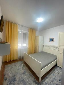 a bedroom with a bed and a yellow curtain at Apartament Nich in Mangalia