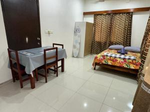 a dining room with a table and a bed at Cozy Self-contained Unit in Lautoka