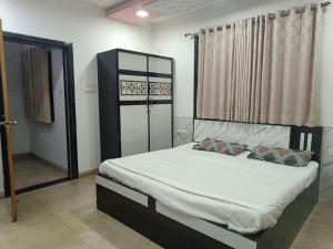 a bedroom with a bed with white sheets and pillows at Hangout Villa in Malavli