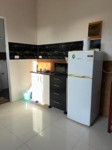 a kitchen with a white refrigerator and a microwave at Cozy Self-contained Unit in Lautoka +1 photo