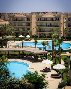 an aerial view of a resort with two pools and umbrellas at The view resort nabq in Sharm El Sheikh