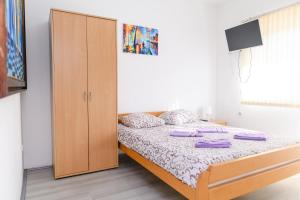 a bedroom with a bed and a wooden cabinet at Studio Merlin 2 in Soko Banja