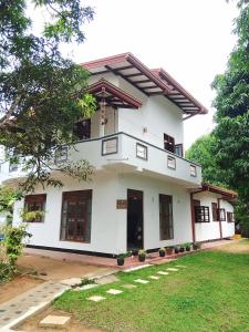 a white house with windows and a yard at Sajini Villa in Weligama