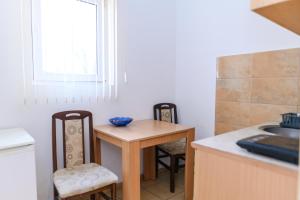 a kitchen with a table and chairs and a sink at Studio Merlin 2 in Soko Banja