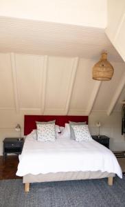a bedroom with a large white bed with a red headboard at Riverfront Guesthouse ,Watermeadows farm in Sedgefield