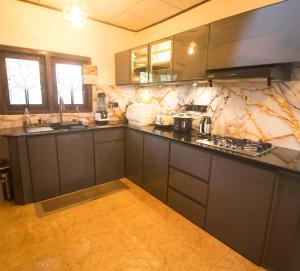 a kitchen with gray cabinets and marble counter tops at Suriya Homestay Mirissa in Mirissa +66 photos