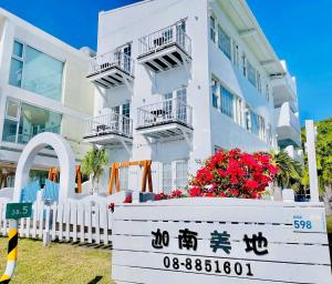 a white building with flowers in front of it at Canaan B&B Kenting in Eluan