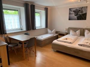 a bedroom with a bed and a table and a dining room at Gästehaus Kirchenbauerhof in Günzburg +53 photos