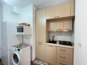 a kitchen with a refrigerator and a washing machine at Apartament Nich in Mangalia