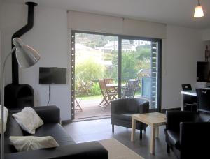 een woonkamer met een bank en stoelen en een patio bij Casa Das Furnas in Furnas