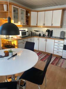 a kitchen with a white table and chairs at Little adorable red in Kiruna +10 photos