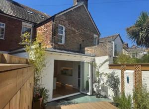 an extension to a brick house with a patio at Harbour Retreat Cottage 3 bedroom in Poole