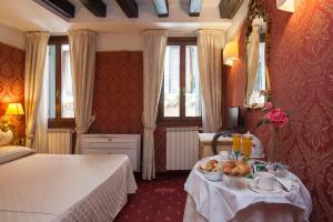 a bedroom with a bed and a table with food on it at Ca' Della Loggia in Venice