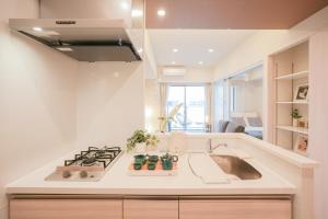 a white kitchen with a sink and a stove at AYA Residence大阪城公園 Osaka Castle JR Morinomiya 徒歩5min in Osaka +84 photos