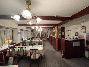 a dining room with tables and chairs in a restaurant at ペンションあけまの森 in Daisen