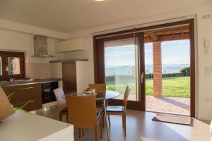 una cucina e una sala da pranzo con tavolo e porta a vetri di Country House Ca' Brunello a Urbino