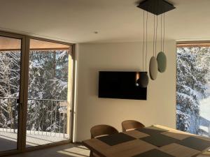 a dining room with a table and a television on the wall at The Mountain Nest in Russbach am Pass Gschütt
