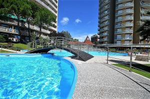 a swimming pool with a bridge in a building at Torre 13F SeaView Studio in Lignano Sabbiadoro