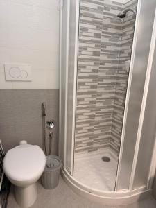 a bathroom with a shower with a toilet and a sink at Torre 13F SeaView Studio in Lignano Sabbiadoro +5 photos