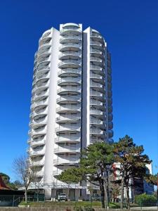 a tall white building with trees in front of it at Torre 13F SeaView Studio in Lignano Sabbiadoro
