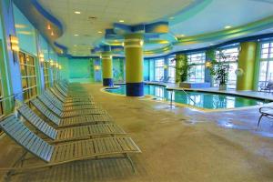 a swimming pool with a row of chairs in a building at 14th Floor 2 BR Resort Condo Direct Oceanfront Wyndham Ocean Walk Resort Daytona Beach 1401 in Daytona Beach