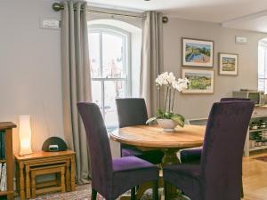 a dining room with a wooden table and purple chairs at Jorvik- Woodsmill Quay in York