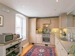 a large kitchen with wooden cabinets and a rug at Jorvik- Woodsmill Quay in York