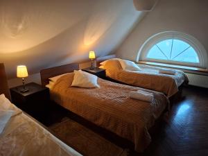 two beds in a room with a window at Dom Retro Pivnica in Jastrzębie Zdrój +38 photos