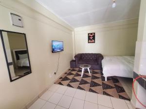 a bedroom with a bed and a mirror and a chair at Nimmoh home in Rungiri