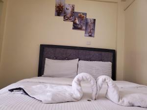 a bed with two swans made to look like snakes at Nimmoh home in Rungiri +3 photos