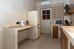 a kitchen with a white refrigerator and a microwave at Bosi Suites 2 in Zakynthos +24 photos
