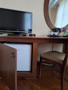 a desk with a tv and a mirror and a chair at Dom Retro Pivnica in Jastrzębie Zdrój