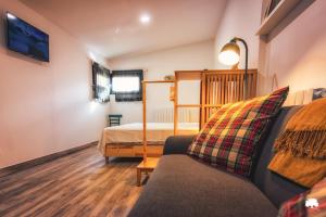 a living room with a couch and a bed at Albergue La Incera in San Martín