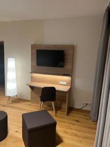 a room with a desk with a television and a chair at Die Meissen Lodge in Meißen