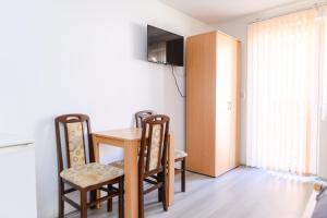 a room with a table and chairs and a television at Studio Merlin 4 in Soko Banja