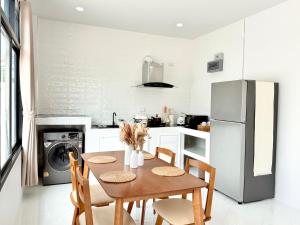 a kitchen with a table with chairs and a refrigerator at Labelle villa koh phangan in Ko Phangan