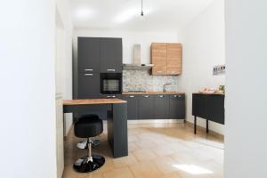 a kitchen with black cabinets and a wooden table at Losa Rooms in Abbasanta +24 photos