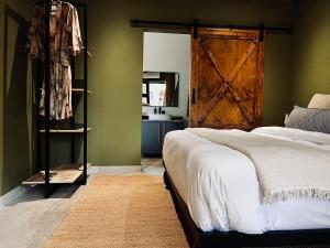 a bedroom with a bed and a barn door at Rhula Villa - Stylish Private Safari Villa in Hoedspruit +40 photos