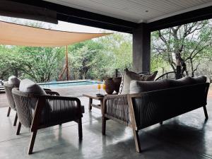 a patio with couches and a table and a pool at Rhula Villa - Stylish Private Safari Villa in Hoedspruit