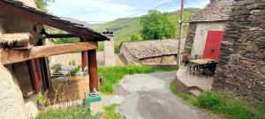 an outdoor area with a red door and a table at Maison au calme entre Causses and Cévennes in Barre-des-Cévennes