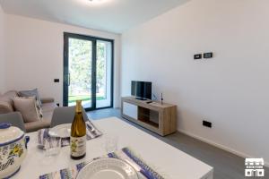 a living room with a table with a bottle of wine at SYMPHONY HOUSE by Design Studio in Bellano