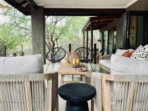 a patio with a table and chairs on a porch at Rhula Villa - Stylish Private Safari Villa in Hoedspruit