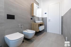 a bathroom with a white toilet and a sink at SYMPHONY HOUSE by Design Studio in Bellano +12 photos