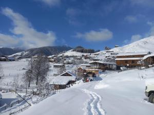 a snow covered village with a snow covered mountain at Tusheti Winter Home in Omalo +6 photos