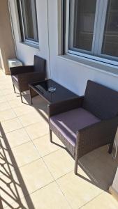 three wicker chairs and a table on a balcony at City Comfort Sparti in Sparta