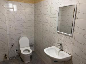 a bathroom with a sink and a toilet and a mirror at Karafuu Nyama Choma Lodge in Bwejuu +44 photos