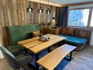 a dining room with a wooden table and green chairs at Das Lisal in Zell am Ziller