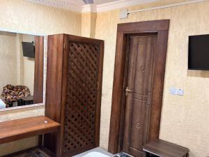 a room with a wooden door and a television at Karafuu Nyama Choma Lodge in Bwejuu